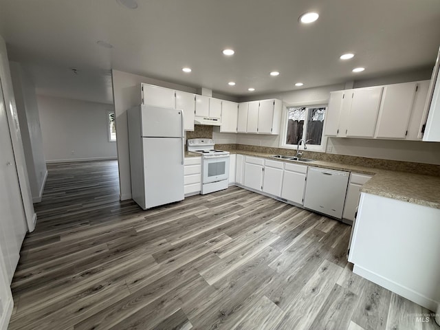 kitchen featuring recessed lighting, wood finished floors, white appliances, white cabinetry, and a sink