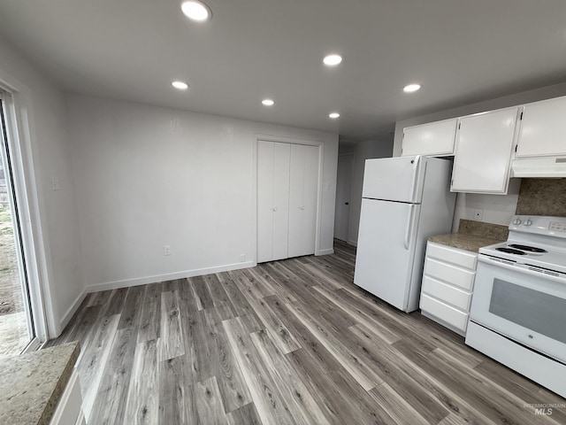 kitchen with under cabinet range hood, recessed lighting, white appliances, white cabinets, and light wood finished floors