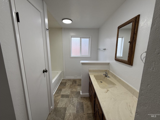 bathroom with baseboards, vanity, and stone finish floor