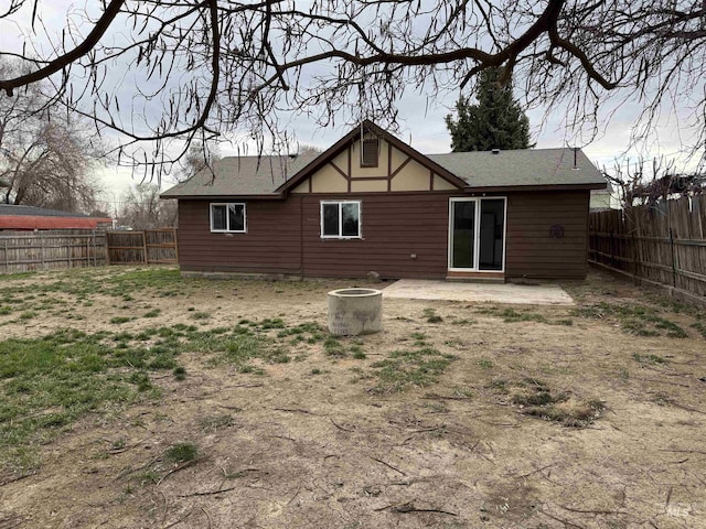 back of property featuring a fenced backyard and roof with shingles