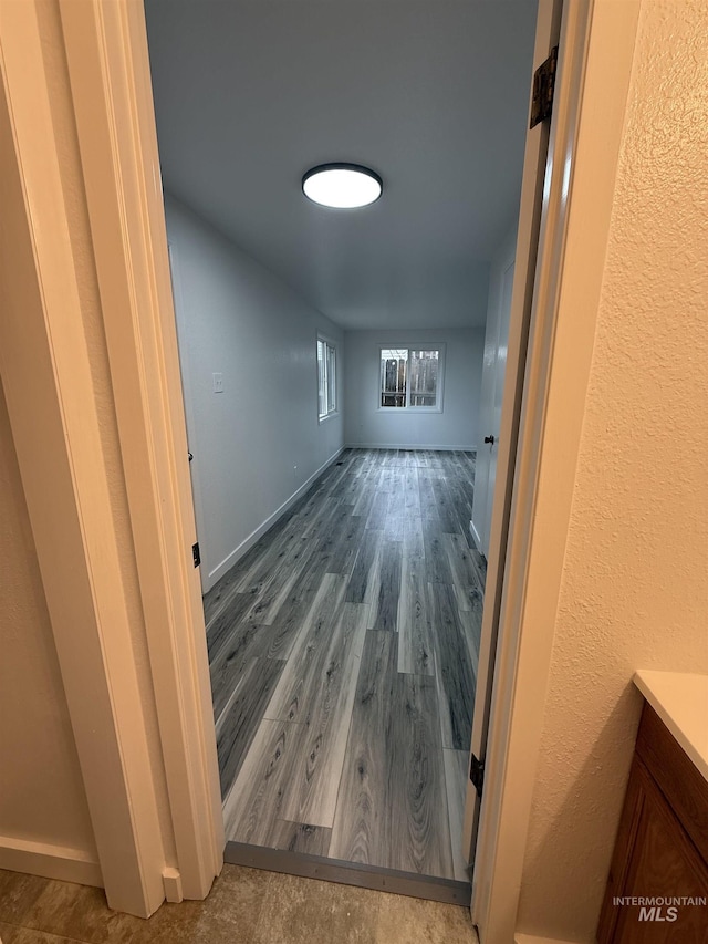 interior space with baseboards and wood finished floors