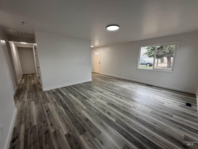 spare room with visible vents, baseboards, and wood finished floors