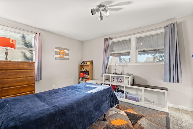 carpeted bedroom with ceiling fan and multiple windows