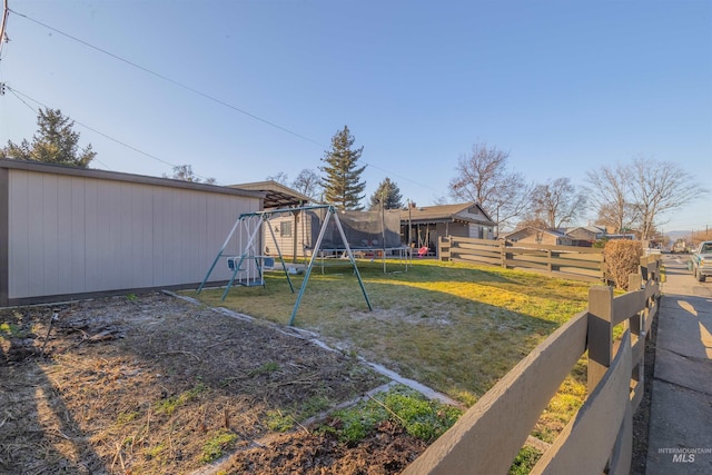 view of yard with a playground and a trampoline