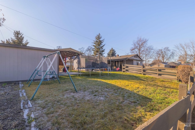 view of yard with a trampoline and a playground