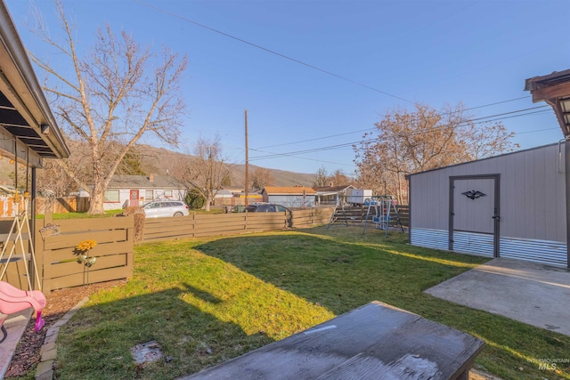 view of yard with a storage shed and a patio