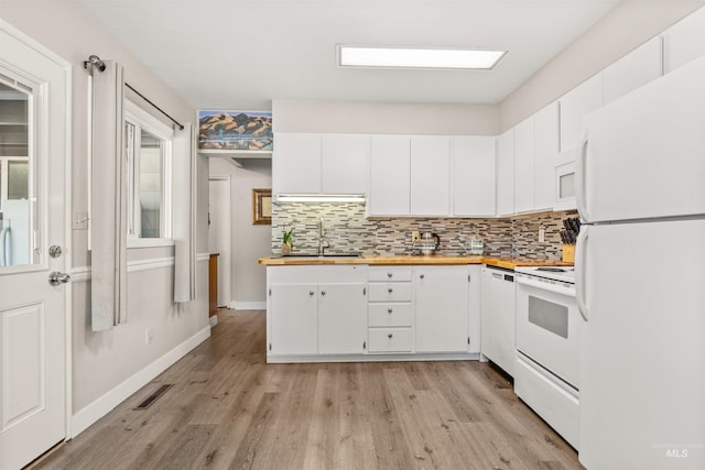 kitchen featuring white appliances, white cabinetry, tasteful backsplash, sink, and light wood-type flooring