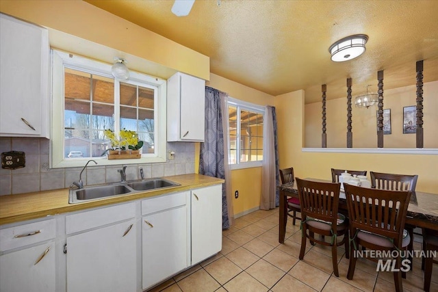 kitchen featuring white cabinets, a sink, and backsplash