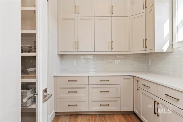 kitchen featuring light hardwood / wood-style floors and backsplash