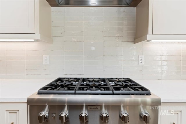 kitchen featuring white cabinetry, extractor fan, decorative backsplash, and range