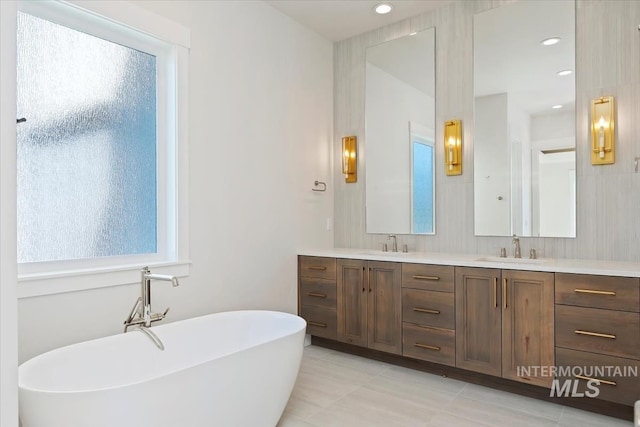 bathroom with vanity, a bathtub, and plenty of natural light