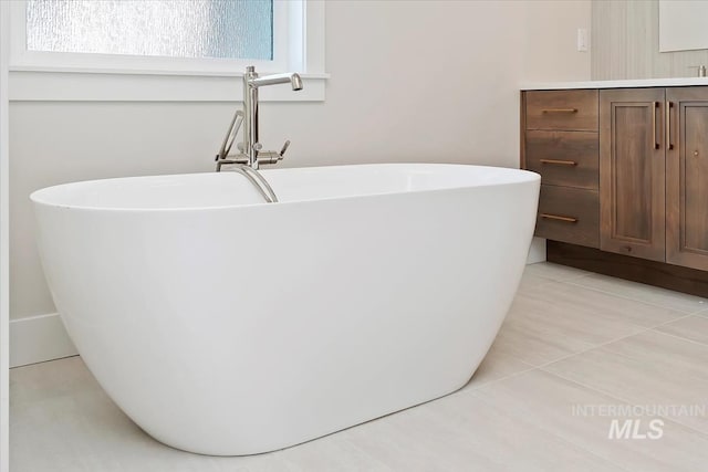 bathroom with vanity, a bath, and tile patterned flooring