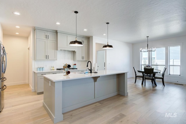 3661 S Corabell Way, Meridian, ID 83642 - kitchen with a sink, light wood-style floors, light countertops, tasteful backsplash, and baseboards