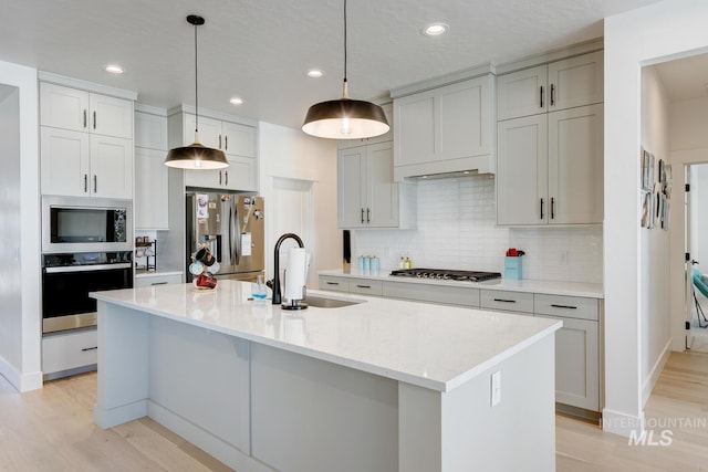 3661 S Corabell Way, Meridian, ID 83642 - kitchen featuring appliances with stainless steel finishes, a sink, light wood-style flooring, tasteful backsplash, and recessed lighting