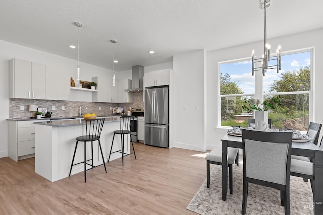 509 E Violets Cove Ln, Garden City, ID 83714 - kitchen with a center island, open shelves, wall chimney range hood, light wood finished floors, and stainless steel appliances