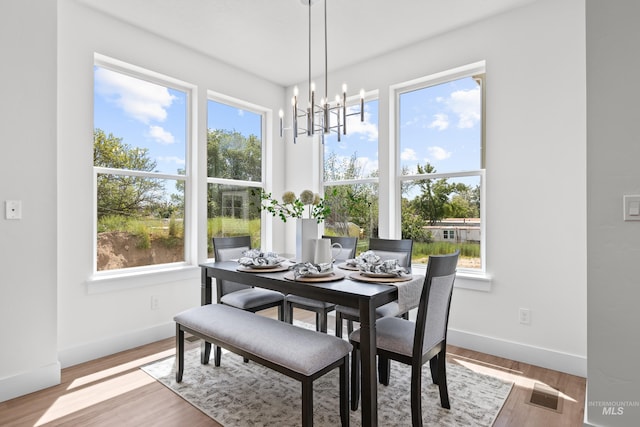 509 E Violets Cove Ln, Garden City, ID 83714 - dining space featuring visible vents, baseboards, a notable chandelier, and wood finished floors