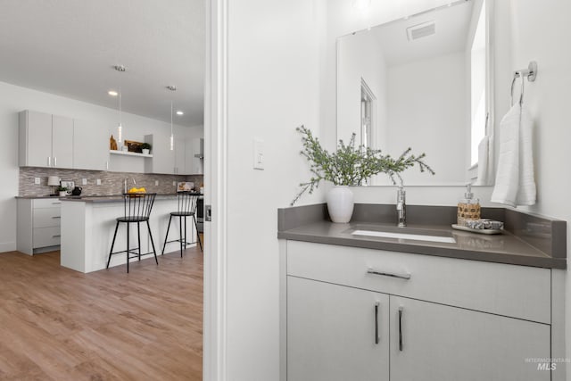 509 E Violets Cove Ln, Garden City, ID 83714 - bar featuring tasteful backsplash, light wood finished floors, visible vents, and a sink