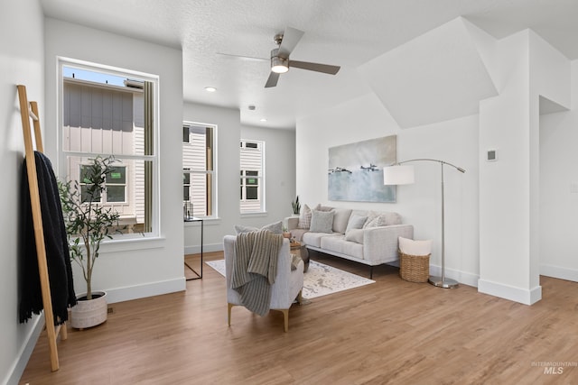 509 E Violets Cove Ln, Garden City, ID 83714 - living area with light wood-style floors, baseboards, a ceiling fan, and a textured ceiling