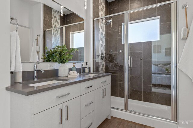 509 E Violets Cove Ln, Garden City, ID 83714 - bathroom with a shower stall, wood finished floors, double vanity, and a sink