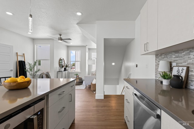 509 E Violets Cove Ln, Garden City, ID 83714 - kitchen with dark wood finished floors, tasteful backsplash, a ceiling fan, white cabinetry, and appliances with stainless steel finishes