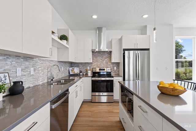 509 E Violets Cove Ln, Garden City, ID 83714 - kitchen with open shelves, wall chimney exhaust hood, appliances with stainless steel finishes, pendant lighting, and a sink