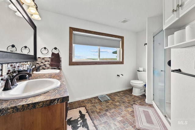 bathroom with toilet, visible vents, decorative backsplash, and a sink