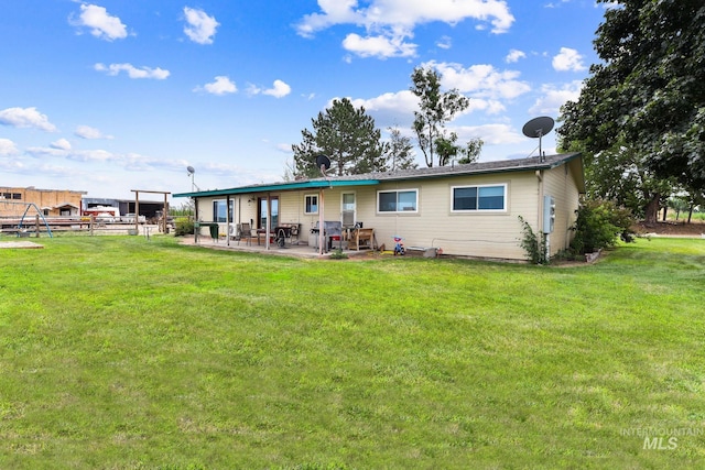 back of property with a yard and a patio area