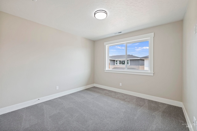 unfurnished room featuring a textured ceiling and carpet