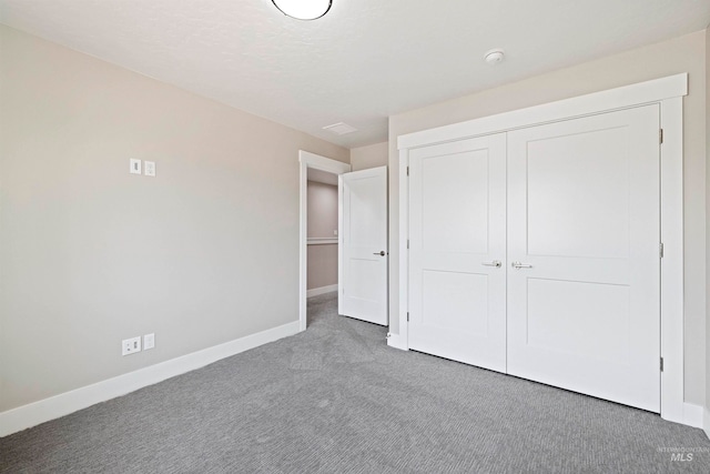 unfurnished bedroom featuring a closet and dark carpet