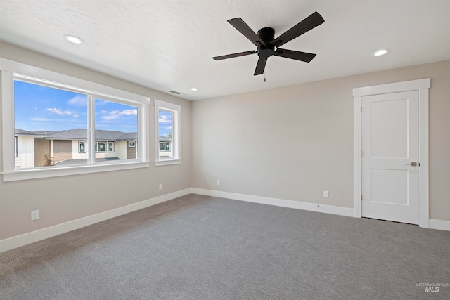 carpeted empty room featuring ceiling fan and a textured ceiling