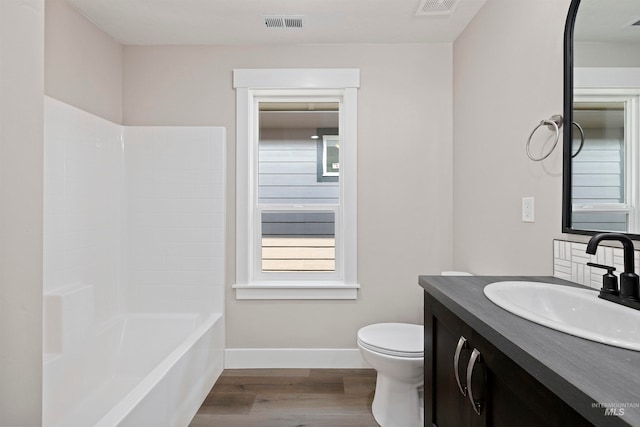 full bathroom featuring wood-type flooring, shower / tub combination, toilet, and vanity