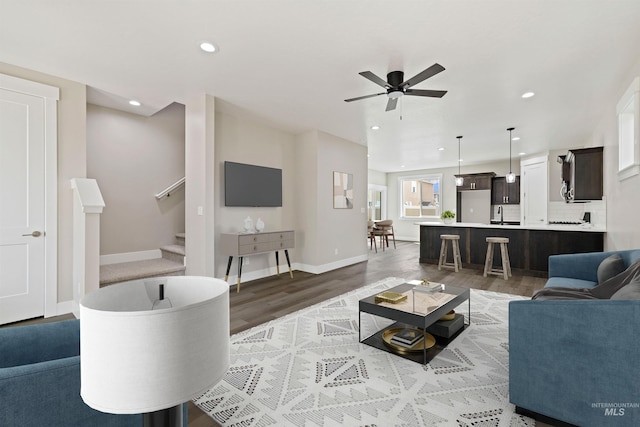 living room with hardwood / wood-style floors, ceiling fan, and sink