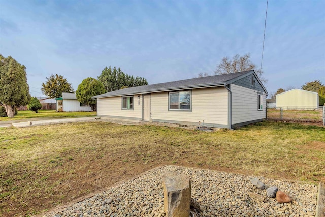 ranch-style home with a front yard and fence