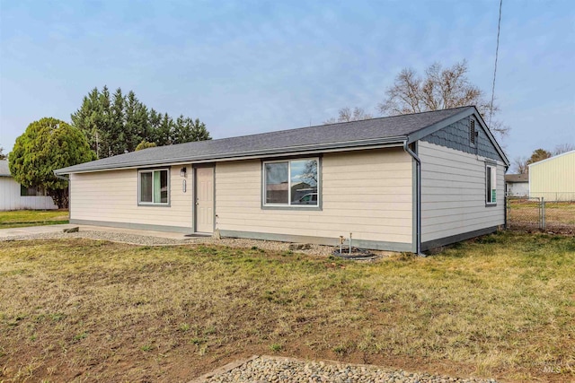 view of front of house featuring fence and a front lawn