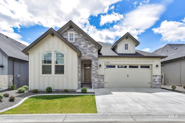 2499 E Berghan Ln, Meridian, ID 83642 - view of front facade featuring board and batten siding, stone siding, a garage, concrete driveway, and a front yard