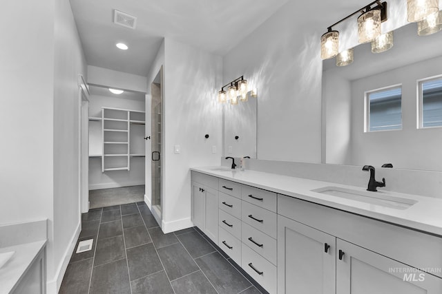 2499 E Berghan Ln, Meridian, ID 83642 - bathroom featuring tile patterned floors, double vanity, a stall shower, and a walk in closet