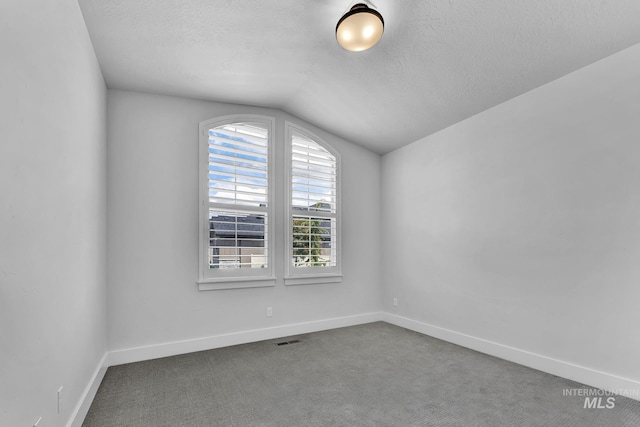 2499 E Berghan Ln, Meridian, ID 83642 - unfurnished room with vaulted ceiling, a textured ceiling, baseboards, and carpet flooring