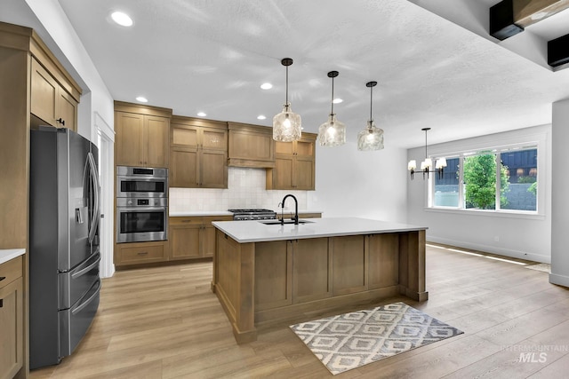 2499 E Berghan Ln, Meridian, ID 83642 - kitchen featuring stainless steel appliances, a sink, brown cabinets, light countertops, and light wood finished floors