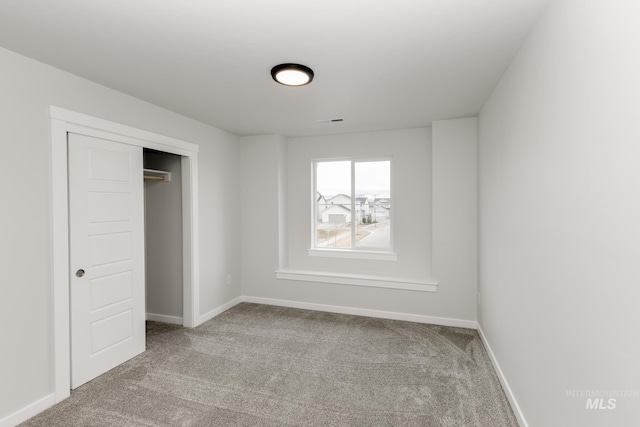 unfurnished bedroom with carpet, visible vents, and baseboards