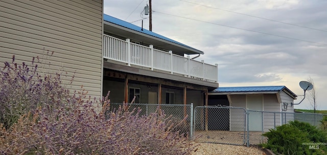 rear view of property featuring fence, a gate, and a wooden deck