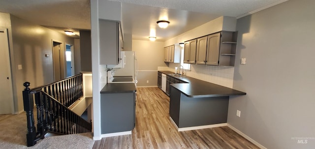 kitchen with dark countertops, light wood finished floors, and baseboards