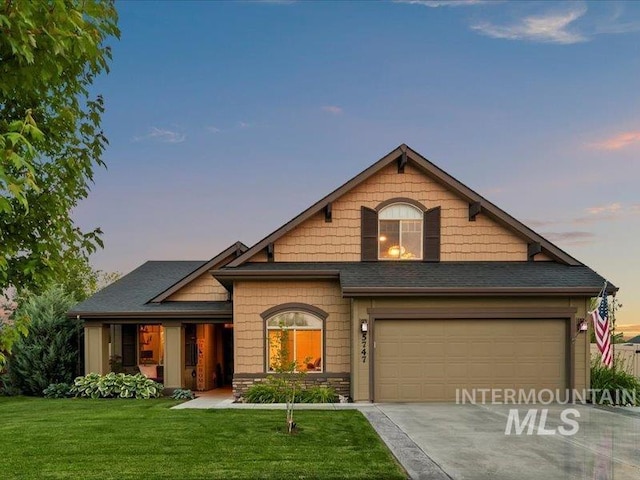 5747 W Rotherham Dr, Eagle, ID 83616 - view of front facade featuring a lawn, driveway, and stone siding