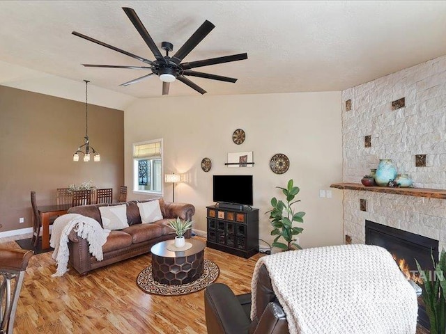 5747 W Rotherham Dr, Eagle, ID 83616 - living area with lofted ceiling, a ceiling fan, wood finished floors, a chandelier, and a fireplace