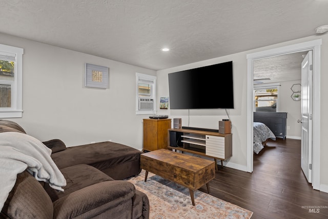 living room featuring dark hardwood / wood-style floors, a wealth of natural light, and a textured ceiling