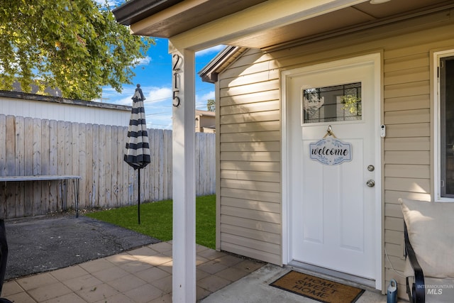 view of exterior entry with a patio