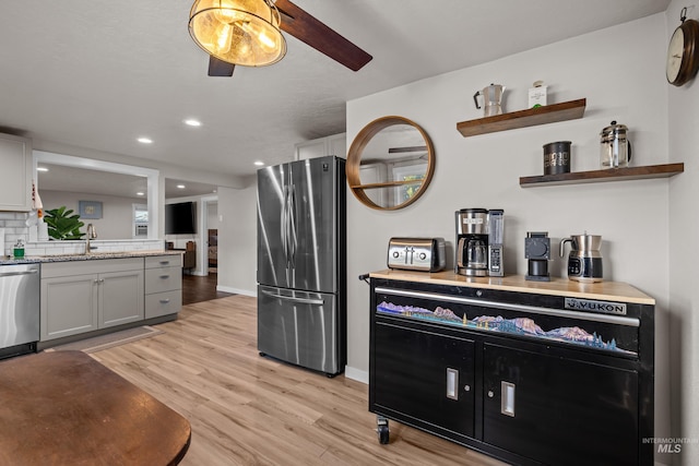 kitchen featuring light hardwood / wood-style floors, gray cabinetry, ceiling fan, sink, and stainless steel appliances