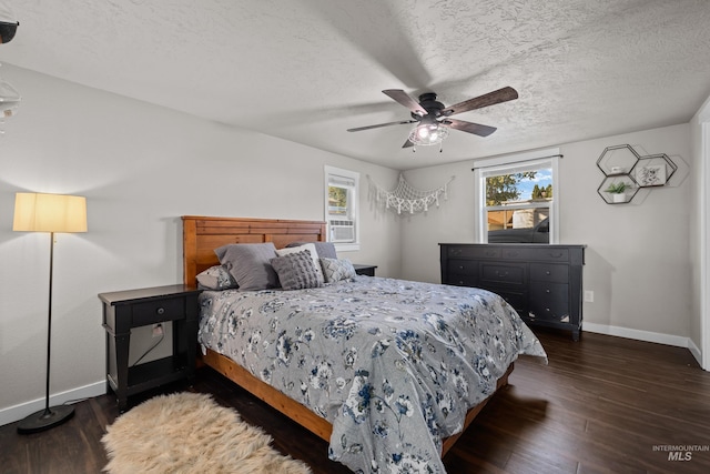 bedroom with multiple windows, ceiling fan, dark hardwood / wood-style floors, and a textured ceiling