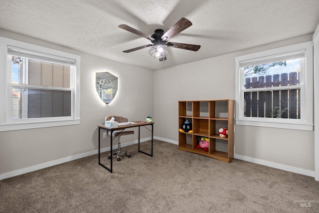 carpeted home office with a textured ceiling and ceiling fan