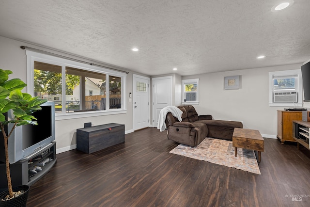 living room featuring dark hardwood / wood-style floors, cooling unit, and a textured ceiling