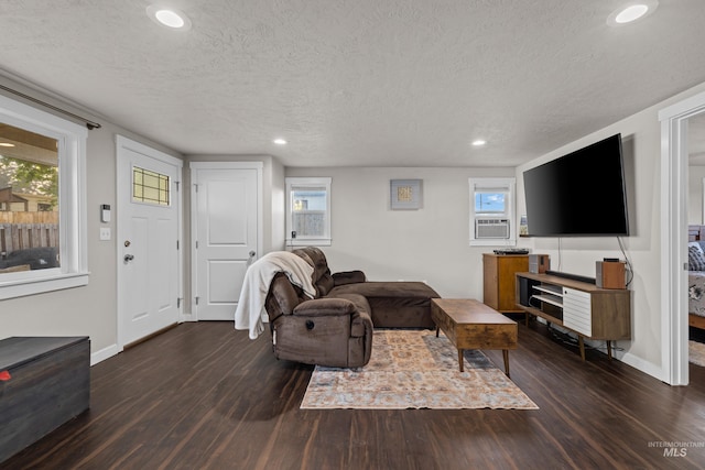 living room with cooling unit, a textured ceiling, and dark hardwood / wood-style floors